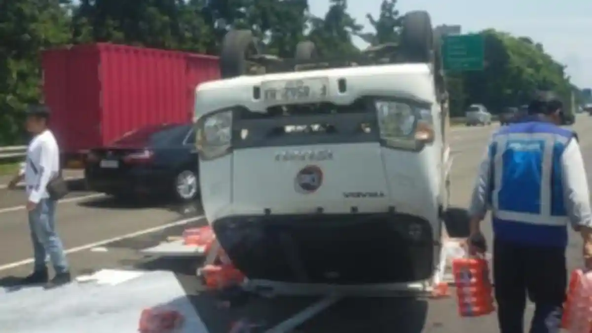 Alami Pecah Ban, Mobil Box Bermuatan Air Mineral Terguling di Tol Jagorawi